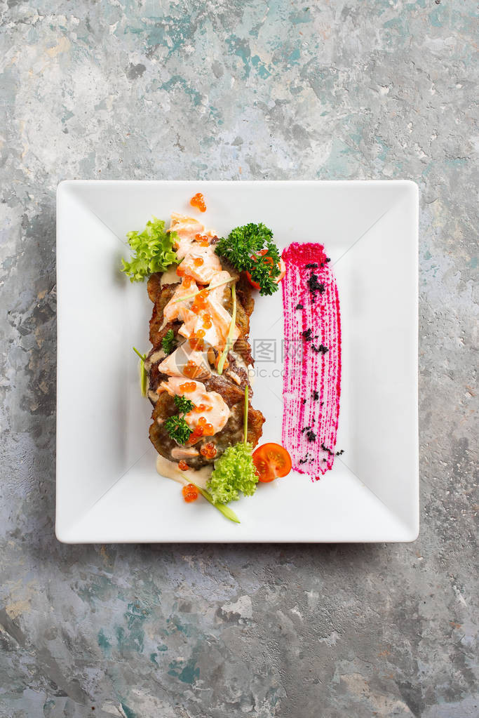 白盘上的蔬菜煮熟的鱼片放在餐桌上图片