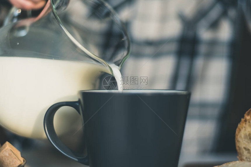 一个女人把牛奶从罐子里倒进杯子里图片