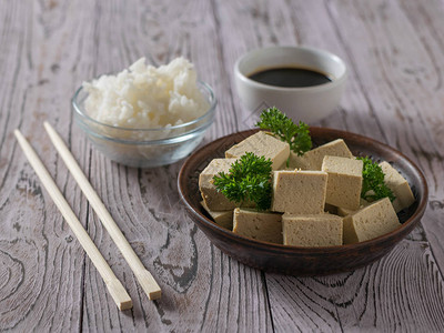豆腐大米酱油和木制桌上的筷子豆奶图片