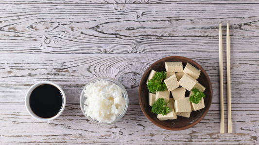 豆腐干酪加面卷酱油和大米放在木制桌子上图片