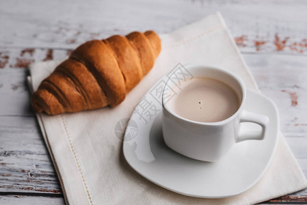 白木桌边的咖啡和羊角面包传统的法国早晚餐图片