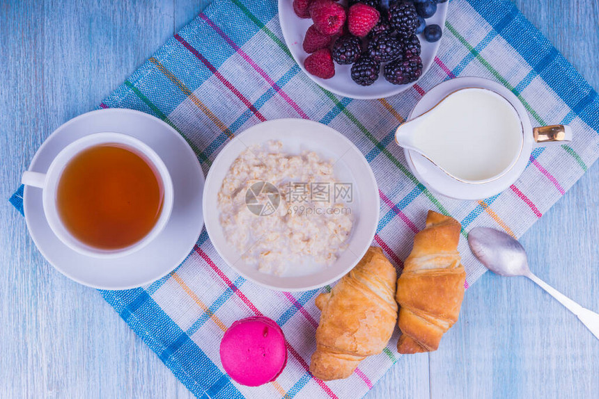 健康早餐带羊角面包的茶和带浆果的燕图片