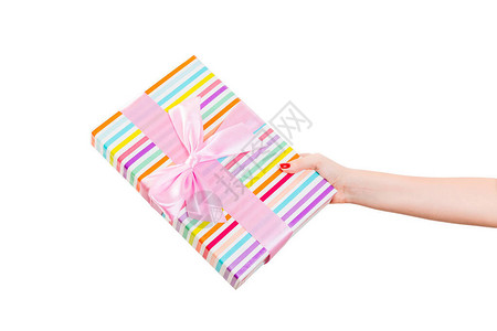 女人的手用粉红丝带用彩纸送上包裹的圣诞或其他节日手工礼物图片