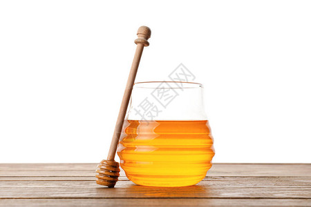 白色背景下桌上的一罐甜蜂蜜背景图片