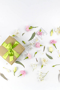 花组成与绿丝带和康乃馨洋桔梗玫瑰干花在白色背景上的礼物妇女节平躺顶视背景图片