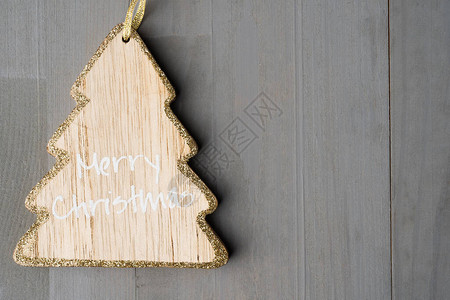 树形装饰品上面有圣诞快乐标志灰色背景图片