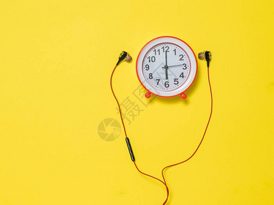 红耳机和黄色背景的红色闹钟创意艺术图片