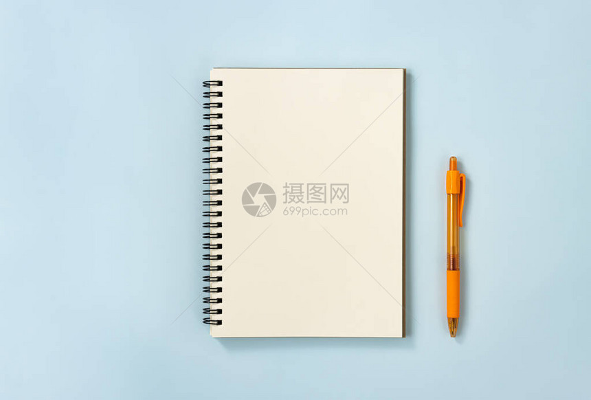 蓝色柔和简约背景上的无衬里类型和橙色笔的螺旋笔记本或弹簧笔记本中心框架上的螺图片