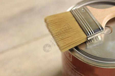 金属罐上的油漆刷子就在旧白色的木板桌上图片