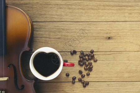 杯咖啡和木板上的小提琴图片