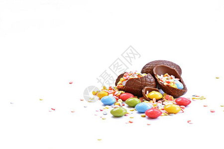 巧克力复活节彩蛋的碎片躺在白色的表面上图片