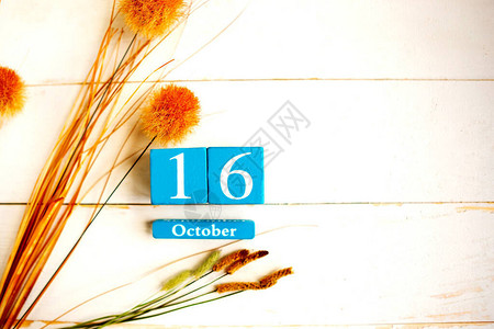 10月16日蓝色立方体日历与木制背景上的月份和日期复图片