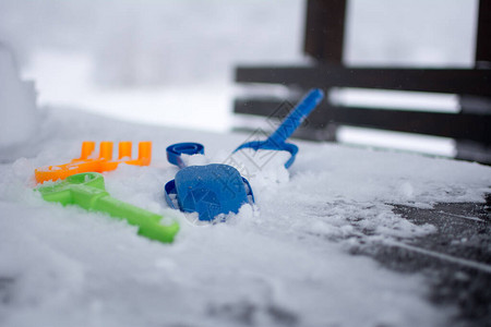 桌上的玩具被雪覆盖在覆盖着雪的背景山中专注于第图片