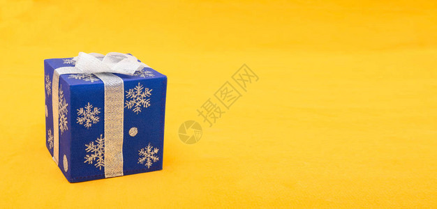 黄色背景横幅上的蓝色圣诞礼物盒图片