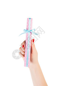 女人的手用粉红色的纸用蓝丝带送上包裹的圣诞或其他节日手工礼物图片