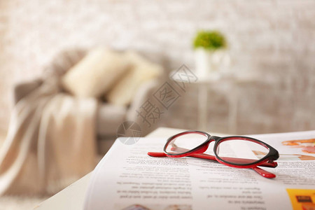 家里桌上放着报纸的时尚眼镜图片