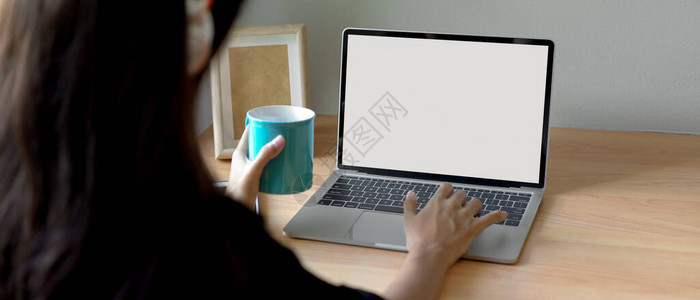 在模拟笔记本电脑和主办公台手持杯子上对女搜索信图片