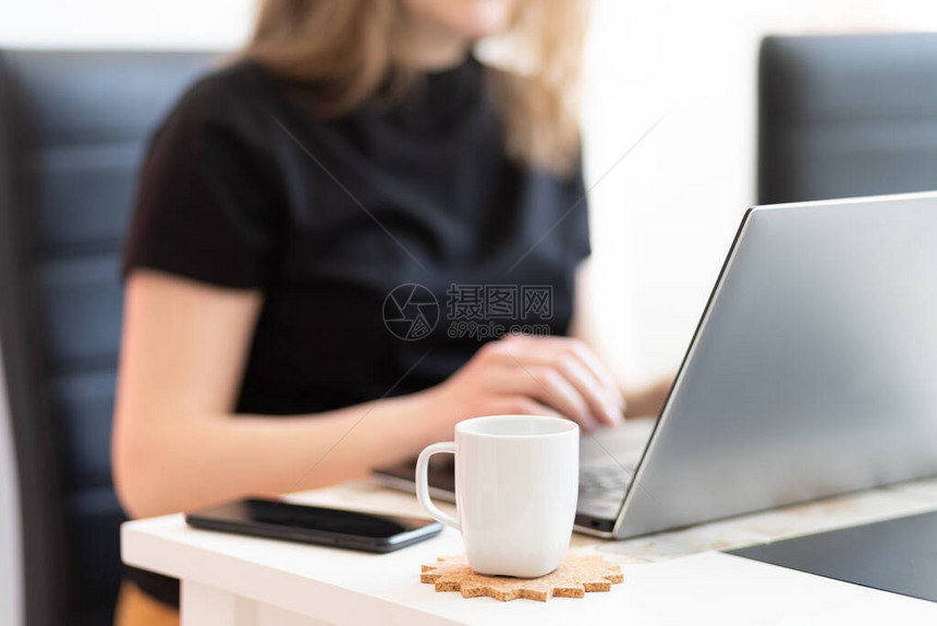 年轻女在办公桌前用文件和笔记本电脑工作时的图像图片