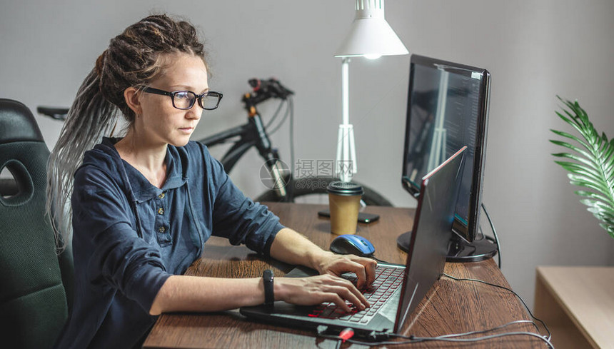 现代年轻女程序员正在家里的笔记本电脑上编写程序代码IT行业的远程工作软图片