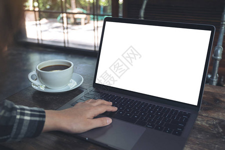 用笔记本电脑空白桌面屏幕和咖啡厅木制桌上的咖啡杯图片
