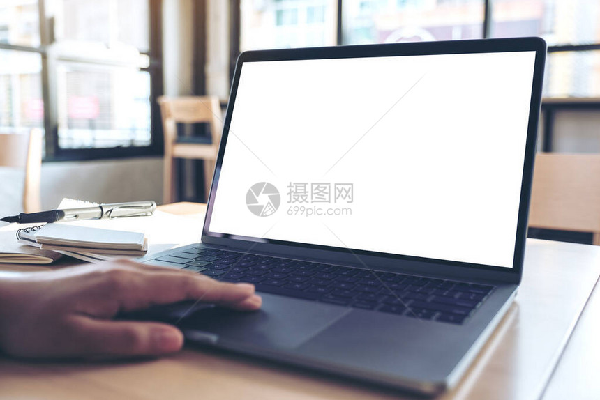 手在办公室使用和触摸手提笔记本电脑触摸板时用空白桌面屏图片