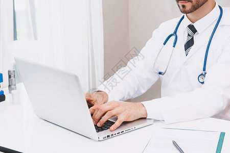 在医院使用笔记本电脑的医生和听诊器图片
