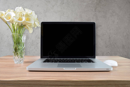 现代笔记本电脑放在浅色木制咖啡桌上背景图片