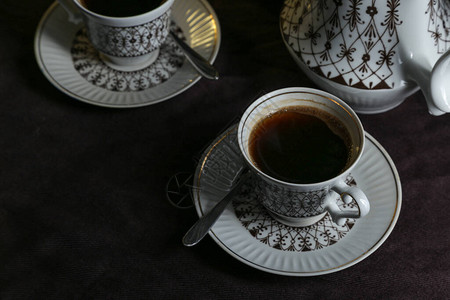 咖啡壶和杯子桌上有咖啡桌边面黑衣桌图片