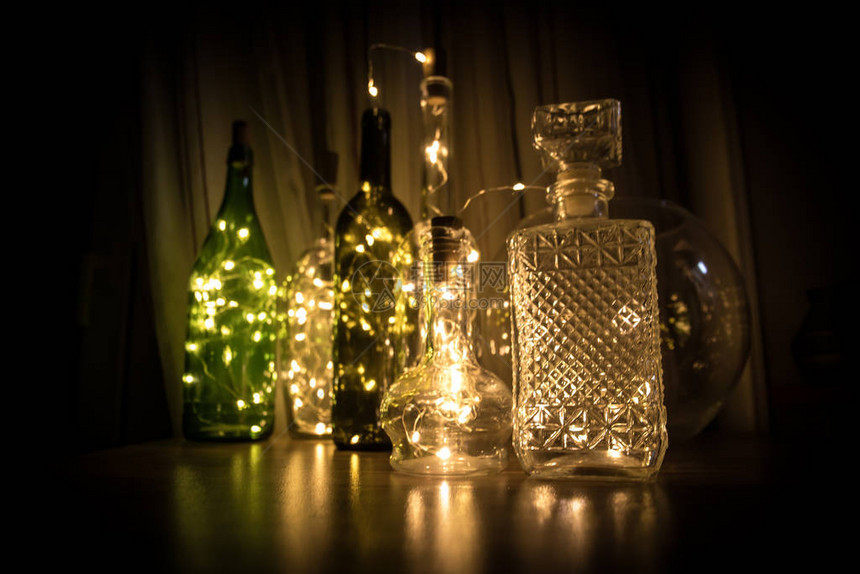 黑暗背景的玻璃瓶中的灯光加兰暖图片