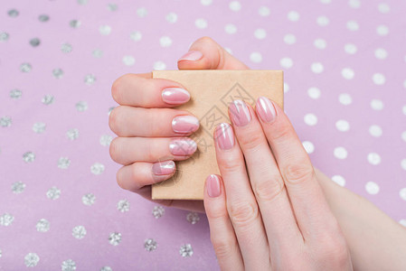 女手中的小纸箱粉红修指甲背景图片