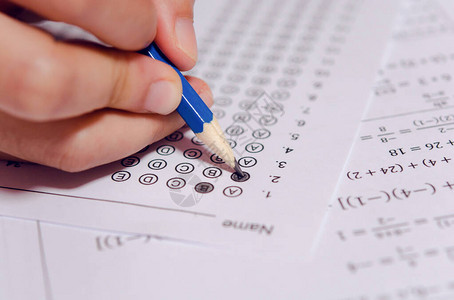 学生手持铅笔在答题纸和问题纸上书写选定的选项学生测试做考图片