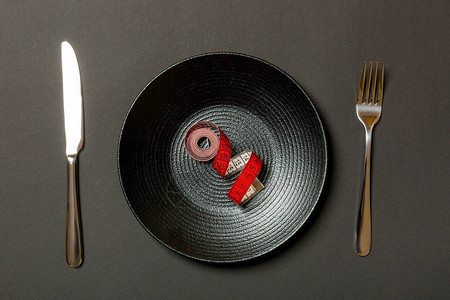 健康饮食的盘子概念用测量胶带叉子和刀图片