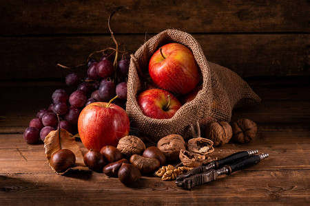 有苹果的袋子一堆葡萄栗子和坚果在图片