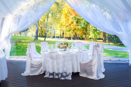 秋天白色户外帐篷内的婚礼餐桌图片