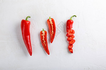 一套新鲜的整体减半和切片的红辣椒在白色背景上顶视图片