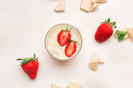 玻璃杯和美味的草莓白桌上背景图片