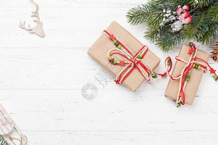 圣诞贺卡与礼品盒和枞树枝在木质纹理背景圣诞背景带有复制空间的顶视图片