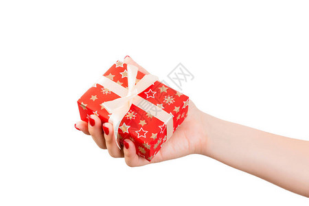 女人的手用金丝带用红纸给包装好的圣诞节或其他节日手工礼物图片