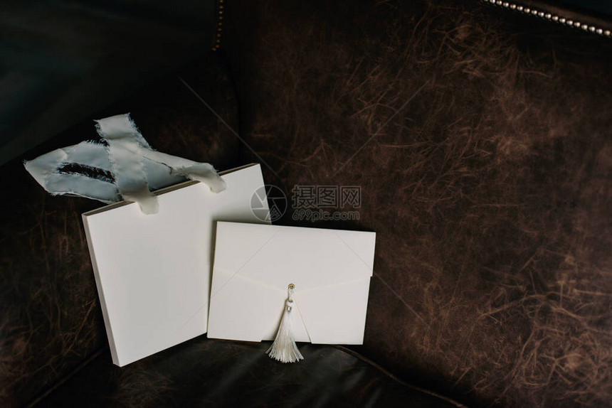 用刷子和纸袋包着礼物包裹的信封上面有棕色背景的丝图片
