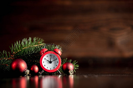 木桌上的老式闹钟和圣诞装饰图片