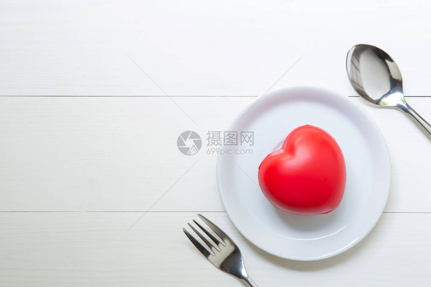 红心与爱和盘子和勺子和叉子在木制背景图片