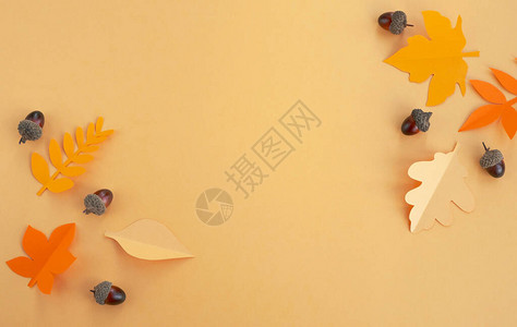 秋季构成用纸和橙色背景的橡树叶制成的叶子顶端视图背景图片