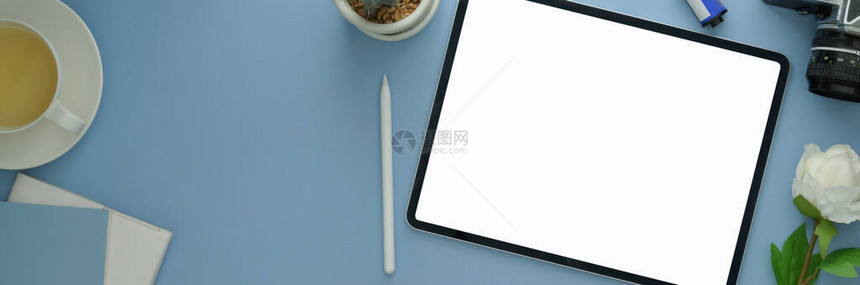 光蓝桌子上有空白屏幕平板日记笔本装饰品和其他用品的创造工作图片