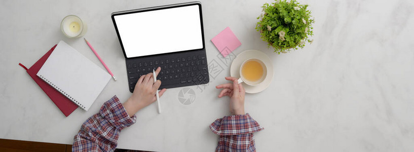 女自由职业者用空白屏幕平板打字用品茶杯和大图片