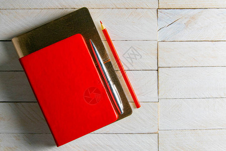 红色笔记本立在笔记本上图片