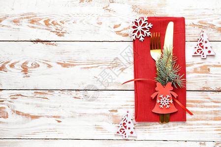 在木制背景上设置圣诞餐桌的餐具和餐巾纸图片