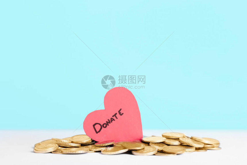 红色的心和桌上的硬币捐赠的概念图片