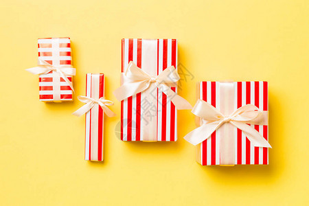 圣诞节或其他节日手工制作的礼物用黄色背景上的黄色丝带用纸包起来图片