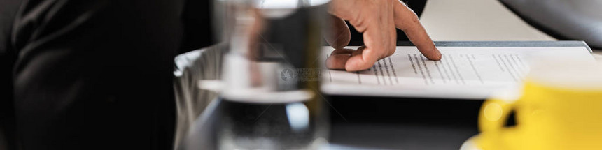 商人在喝咖啡时对文件或合同进行校对的广图片