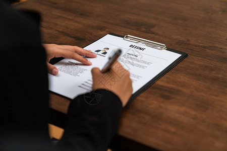女商人在办公桌上填写简历申请信息图片